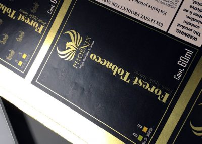 Impresion-en-adhesivo-metalizado-oro-con-tinta-blanca-y-barniz-a-registro-y-laminado-mate